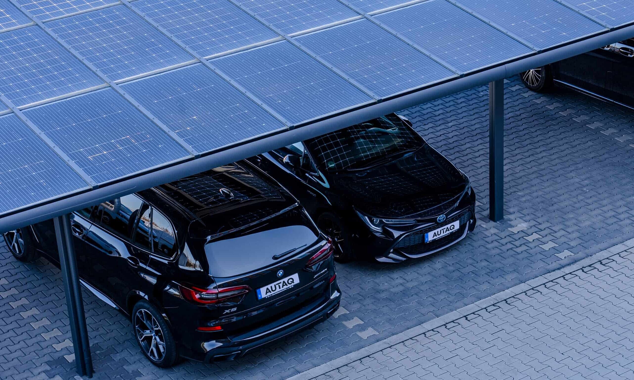 Ansciht von oben: zwei Autos stehen unter einem Solarcarport